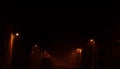 Germany on night - a foggy, dark street in a small town lit by a weak orange light of night lamps Royalty Free Stock Photo