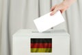 Germany Vote concept. Voter hand holding ballot paper for election vote on polling station