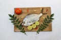 Gerres Fish (Gerres Filamentosus)   Whipfin silver biddy Fish   Decorated with curry Leaves and Tomato on a Wooden pad. Royalty Free Stock Photo