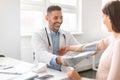 Gestational hypertension. Male doctor measuring arterial blood pressure of young pregnant lady using cuff Royalty Free Stock Photo