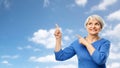 Smiling senior woman pointing fingers to sky Royalty Free Stock Photo