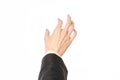 Gestures and Business theme: businessman shows hand gestures with a first-person in a black suit on a white background isolated