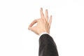 Gestures and Business theme: businessman shows hand gestures with a first-person in a black suit on a white background isolated