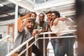 They get along so well as a team. a group of young creatives taking selfies together in an office.