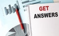 GET ANSWERS text on a notebook with pen on a chart background
