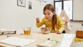 Get Cereals and become stronger. Caucasian cute little girl eating cereal balls with milk for her breakfast or lunch Royalty Free Stock Photo