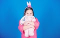 Get in easter spirit. Happy childhood. Bunny ears accessory. Lovely playful bunny child hugs soft toy. Have blessed