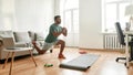 Get Fit At Home. Full length shot of young active man watching online video training on laptop, exercising, stretching