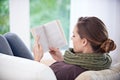 Get lost in a good book. Rear-view shpt of a woman reading a book at home.