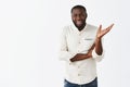 Get out of my way. Portrait of displeased African American man in white shirt, waving with palm and frowning