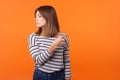 Get out! Portrait of resentful woman with brown hair in long sleeve shirt. indoor studio shot isolated on orange background