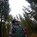 Get out to get inspired. Low angle view of a handsome rugged man looking up toward tree tops.