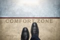 Get out of your comfort zone. Comfort Zone Concept, Male with Leather Shoes Steps over a word with line on Concrete Floor, Top Royalty Free Stock Photo