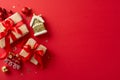 Flat lay top view of rustic gift boxes, playful Christmas tree ornaments like a train and house showcased on red background