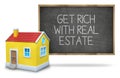 Get rich with real estate on blackboard Royalty Free Stock Photo