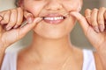 Get into the routine of healthy habits. Portrait of a young woman flossing her teeth in the bathroom. Royalty Free Stock Photo