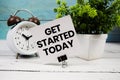 Get Started Today text written on paper card with alarm clock on wooden background Royalty Free Stock Photo