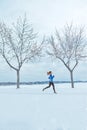 Get stronger, tougher, faster, healthier and happier. a woman wearing warm clothing while out for a run through the snow