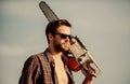 Get stylish haircut. Barbershop concept. Masculinity concept. Handsome man with chainsaw blue sky background. Dangerous