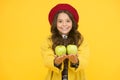 Get vitamin start to school year. Happy girl hold vitamin fruit yellow background. Little child smile with green apples Royalty Free Stock Photo