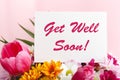 Get Well Soon card in flower bouquet on pink background. Stock photo mock up for text