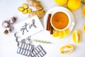 GET WELL - written on piece of paper among the products for the treatment of common cold - lemon, ginger, chamomile tea pills.