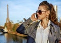 Young trendy woman speaking on smartphone near Eiffel tower Royalty Free Stock Photo