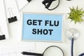 Get Your Flu Shot, written on a paper on table Royalty Free Stock Photo