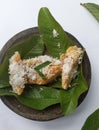 Gethuk on a stone plate with green leaves,gethuk is traditional javanese dish Made from cassava,brown sugar,and coconut shredded.