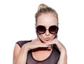 She gets away with it. Portrait of an attractive young woman with sunglasses posing playfully in studio. Royalty Free Stock Photo