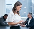 Getting all her tasks done the efficient way. a young businesswoman using a digital tablet in an office with her