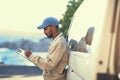 Getting all his logistics down. a delivery man writing on a clipboard while standing next to his van. Royalty Free Stock Photo