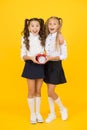 Getting back to class in time. Happy little girls back to school on september 1. Small schoolchildren smiling with clock Royalty Free Stock Photo