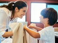 Getting the chores done with my boy. a young attractive mother doing laundry with her son at home. Royalty Free Stock Photo