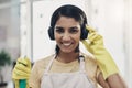 Getting into the domestic goddess groove. a young woman listening to music while cleaning her home.