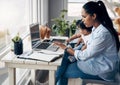 Getting it done. a young mother caring for her baby girl while working from home. Royalty Free Stock Photo