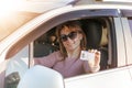 Getting a driver`s license, a beautiful driving girl shows a new driver`s license. Young woman holding driving license near open