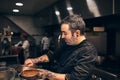 Getting everything ready for the course. Shot of a focused chef preparing a dish in the kitchen of a restaurant.