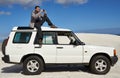 Getting a great shot. a group of a man sitting on a car and taking a photo.