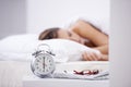 Getting her 8 hours. A woman sleeping in her bed with an alarm clock in the foreground. Royalty Free Stock Photo