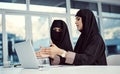 Getting her up to speed. two young arabic businesswomen working on a laptop in their office. Royalty Free Stock Photo