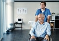 Getting his health back on track. a male nurse caring for a senior patient in a wheelchair. Royalty Free Stock Photo