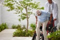 Getting into his ride. a male doctor helping his senior patient into a wheelchair outside.