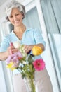 Getting it just right. a senior woman enjoying some flower arranging at home. Royalty Free Stock Photo