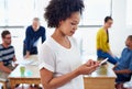 Getting the latest news on her app. Beautiful young businesswoman texting on her phone with her office and staff in the Royalty Free Stock Photo