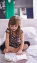 Getting lost in story land. Shot of a little girl reading a book on her bed. Royalty Free Stock Photo