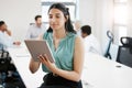 Getting many tasks done in an instant. a confident young businesswoman using a digital tablet in an office.