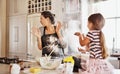 Getting messy is part of the fun of baking together. two little girls having fun while baking with their mother in the Royalty Free Stock Photo