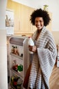 Getting my daily dose of calcium. Portrait of a happy young woman taking a bottle of milk out of the fridge at home.