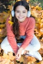 Getting pleasure in simple things. Little girl listen to music. Happy little girl in autumn. Happy child wear headphones